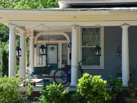 north carolina house blue with covered front porch and a bike
