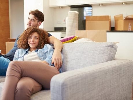 new homeowners sitting together surrounded by boxes