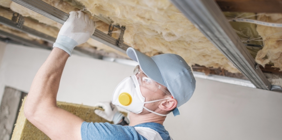 man installing attic insulation