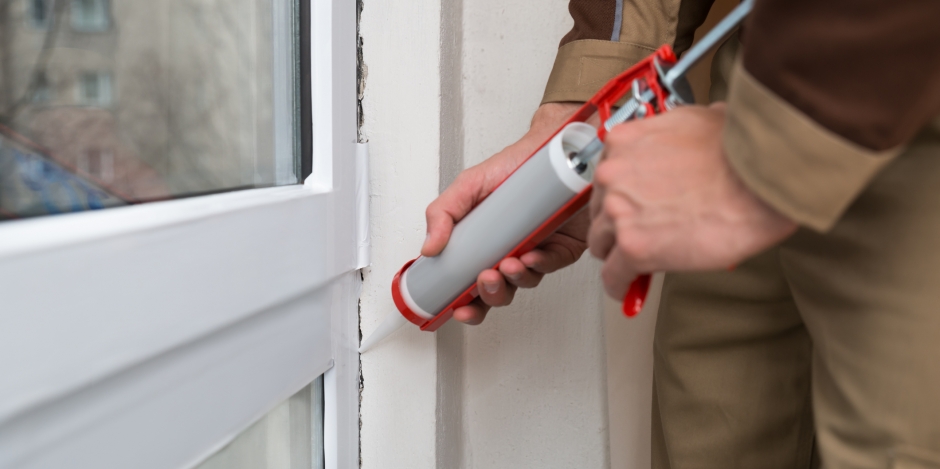 Caulk gun applying caulk on Window sill