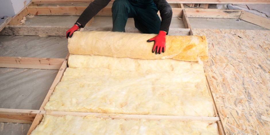 tech installing batt insulation in floor of house