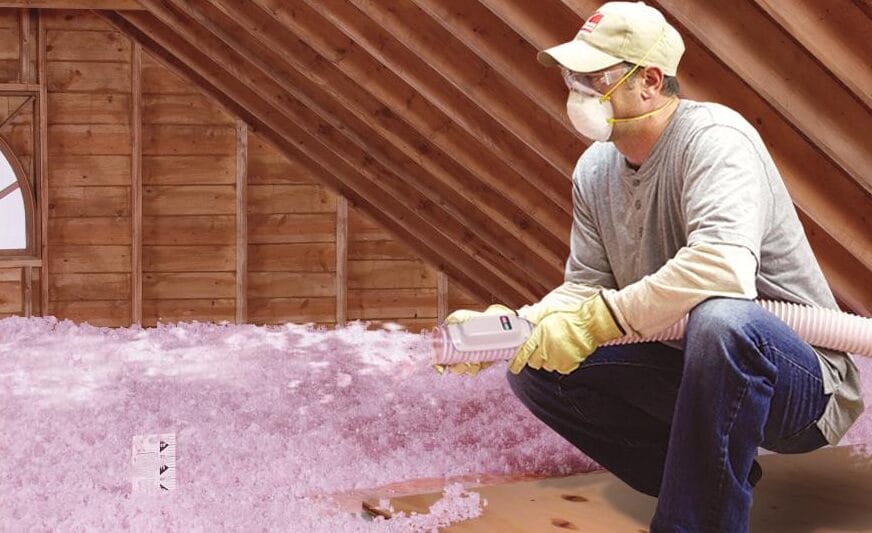 Technician installing blown in attic insulation with photo depth marker