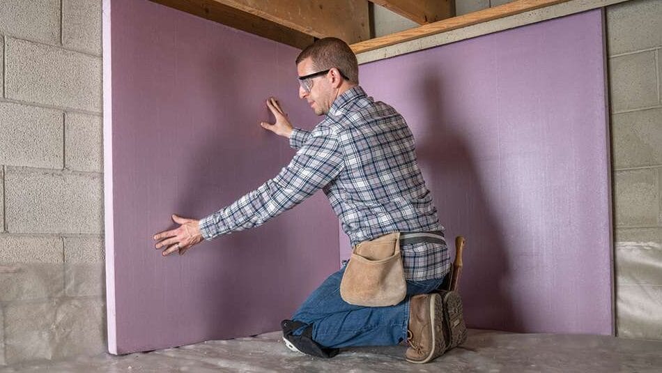 Standard Insulating Company's quality assurance process Standard Insulating Company Insulation technician installing wall board in a crawl space.